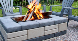 Built-in Outdoor Firepit Seamlessly Integrated into a Patio Design, Creating a Permanent Gathering Space with Glowing Flames