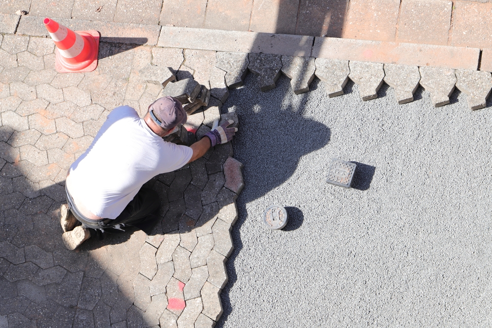 a Worker is Laying Paving Stones in Gravel